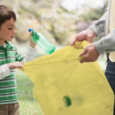 Bambino ricicla rifiuti con sacco giallo